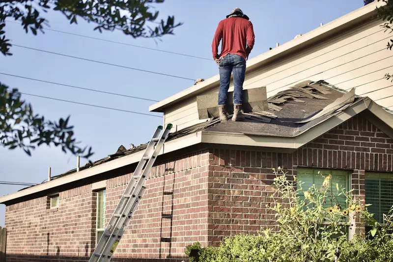 Professional roofer working on a residential roof in East Grand Rapids
